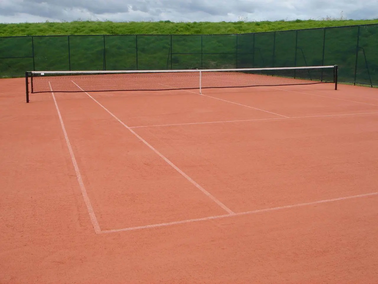 Excess sand infill creates more slide,  high and slow ball bounce.