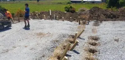 worker on job site with posts in ground